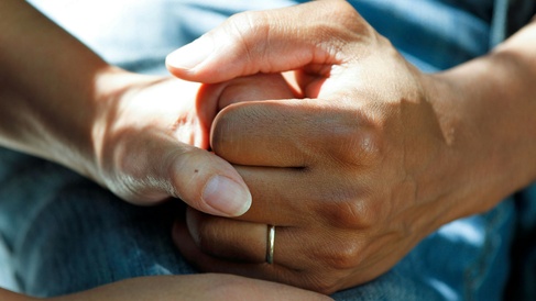 Hands holding on hospital bed
