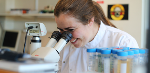 Dr Alecia-Jane Twigger looking through microscope