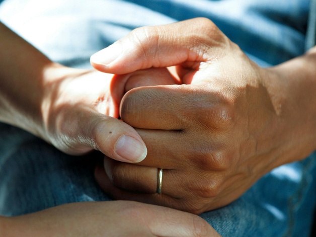 Hands holding on hospital bed