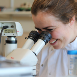 Dr Alecia-Jane Twigger looking through microscope