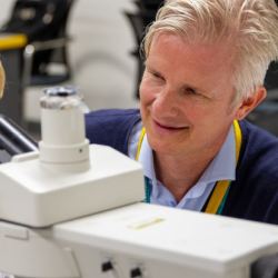 Matt Zilbauer and a young person at the microscope